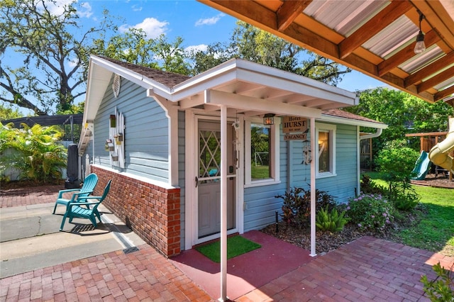 exterior space featuring a playground and brick siding