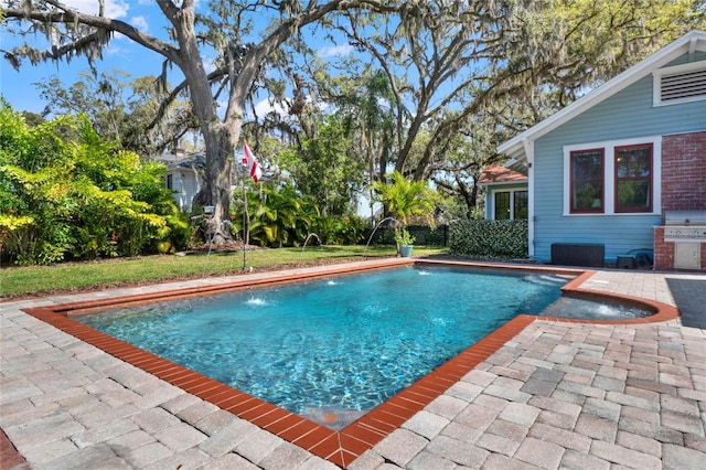 pool with a patio area and a grill