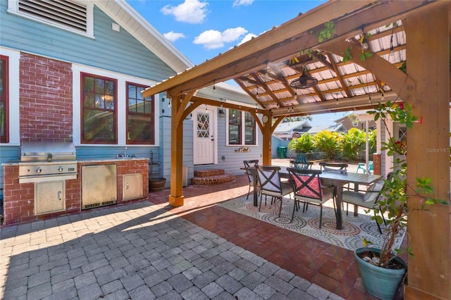 view of patio with entry steps, a grill, exterior kitchen, a sink, and outdoor dining space