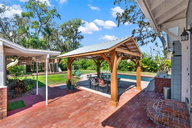 view of patio with outdoor dining space, a playground, and a gazebo