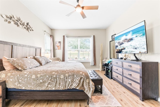 bedroom featuring ceiling fan, baseboards, and light wood-style floors