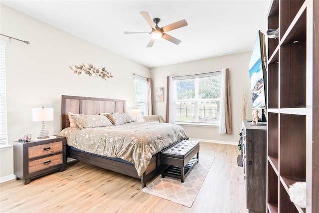 bedroom with baseboards, ceiling fan, and light wood-style floors