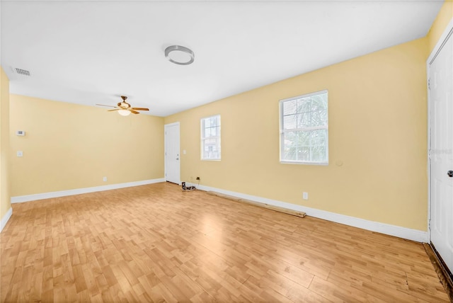 empty room with baseboards, ceiling fan, visible vents, and light wood-style floors