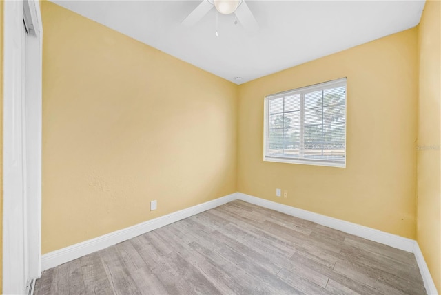 empty room featuring ceiling fan, light wood-type flooring, and baseboards