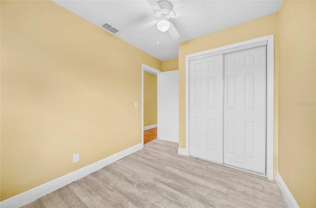 unfurnished bedroom with light wood finished floors, a closet, visible vents, ceiling fan, and baseboards