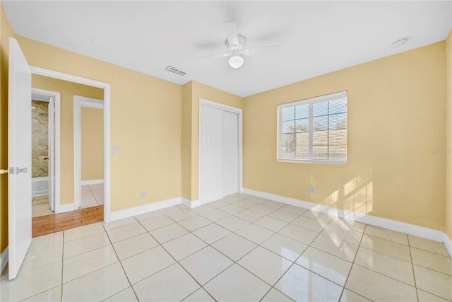 unfurnished bedroom featuring baseboards, visible vents, a closet, and light tile patterned flooring