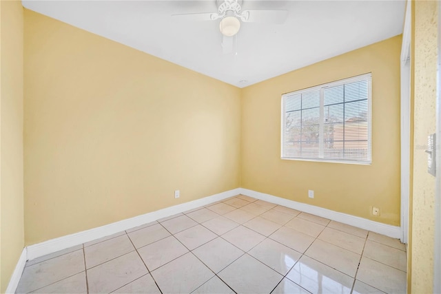 spare room with ceiling fan, baseboards, and light tile patterned floors