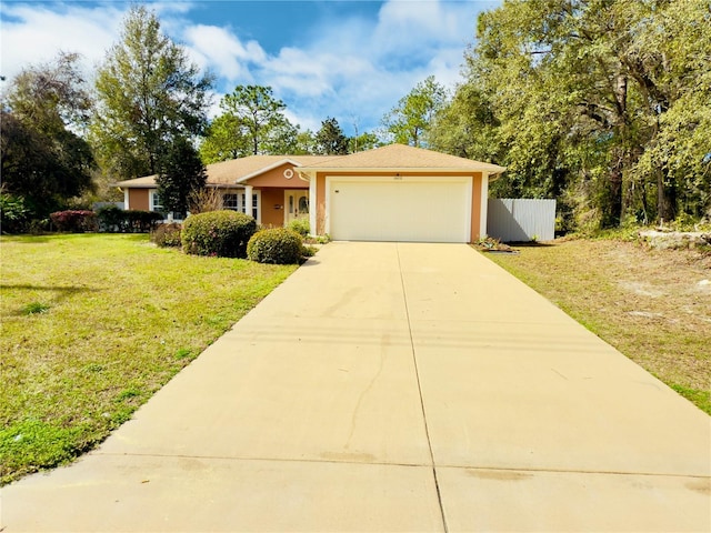 ranch-style home featuring an attached garage, fence, concrete driveway, stucco siding, and a front lawn