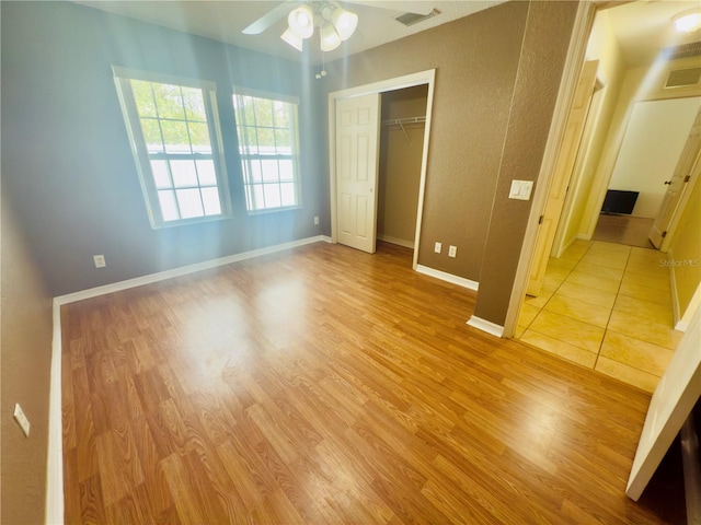 unfurnished bedroom featuring a closet, light wood-type flooring, visible vents, and baseboards