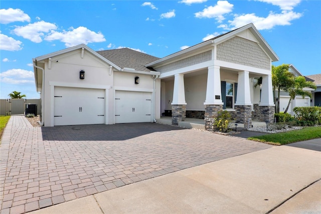 view of front of home featuring an attached garage, a gate, decorative driveway, and stucco siding