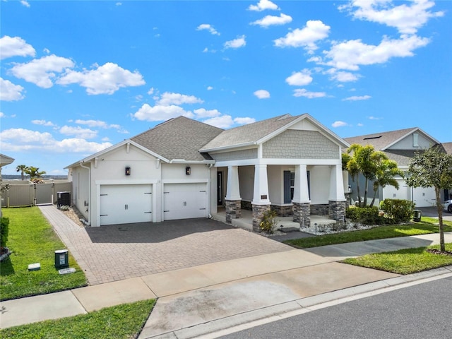 craftsman-style home featuring decorative driveway, a gate, central AC, and stucco siding