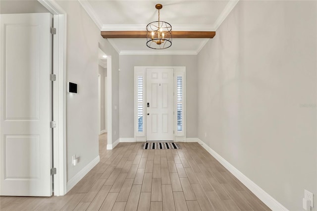 entrance foyer with light wood-style floors, crown molding, a notable chandelier, and baseboards