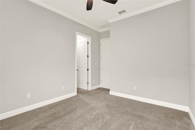 carpeted spare room with a ceiling fan, visible vents, crown molding, and baseboards