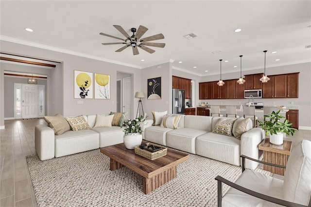 living area featuring recessed lighting, visible vents, and crown molding