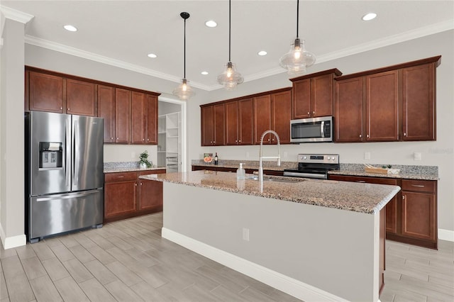 kitchen with light stone countertops, stainless steel appliances, a sink, and wood finish floors