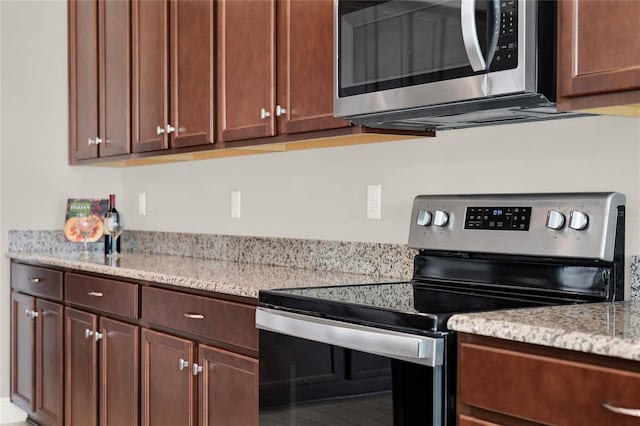 kitchen featuring light stone countertops and stainless steel appliances