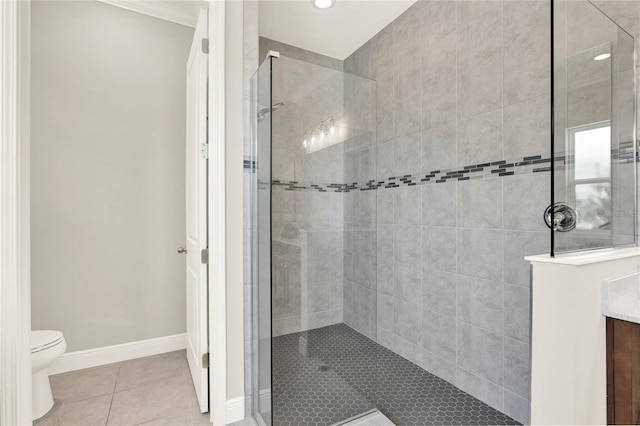 bathroom featuring tile patterned flooring, baseboards, a tile shower, and toilet