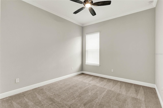 carpeted empty room featuring ceiling fan, ornamental molding, and baseboards