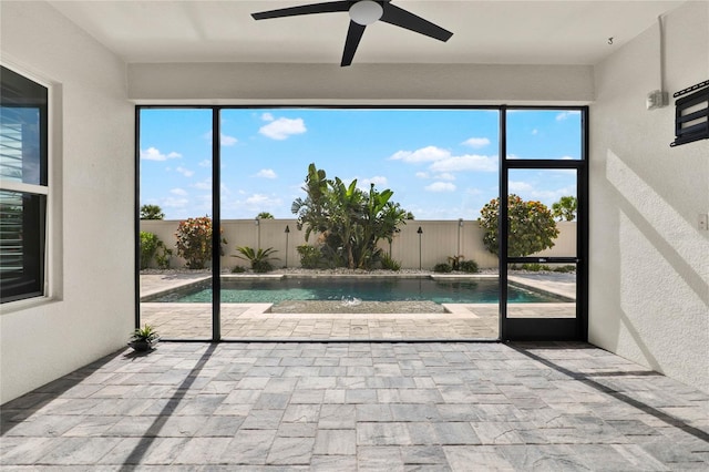 unfurnished sunroom featuring a ceiling fan