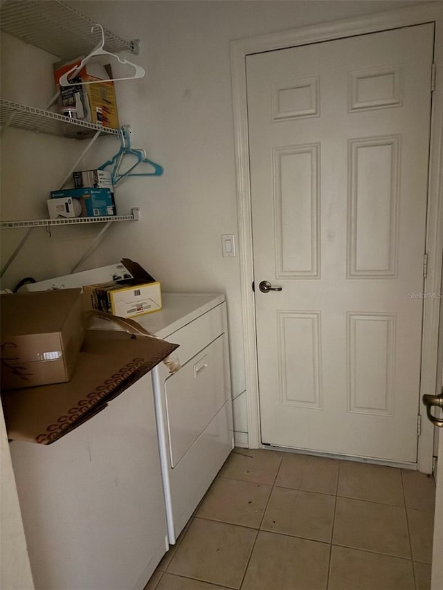 washroom with light tile patterned floors, laundry area, and washer and clothes dryer