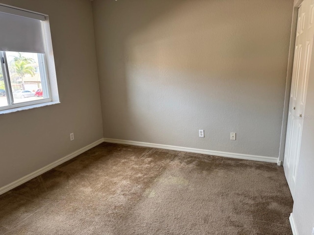 spare room with carpet and baseboards