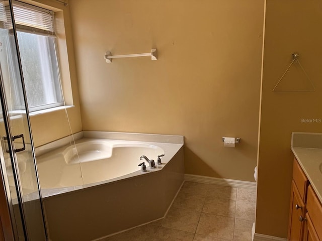 full bathroom featuring a garden tub, toilet, tile patterned flooring, vanity, and baseboards