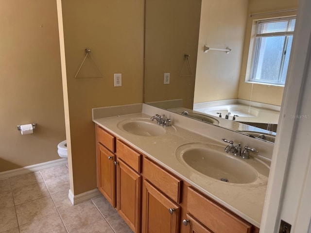 full bath with double vanity, a sink, toilet, and tile patterned floors