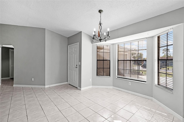 unfurnished dining area with arched walkways, light tile patterned floors, baseboards, and a notable chandelier