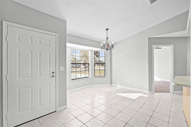 unfurnished dining area with light tile patterned floors, a textured ceiling, a chandelier, and baseboards