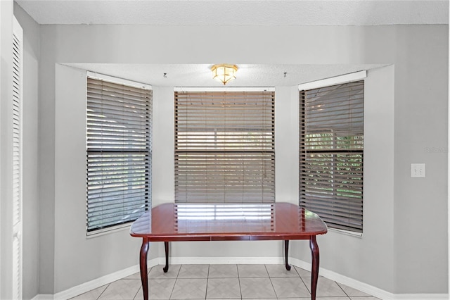 home office featuring a textured ceiling, light tile patterned flooring, and a wealth of natural light