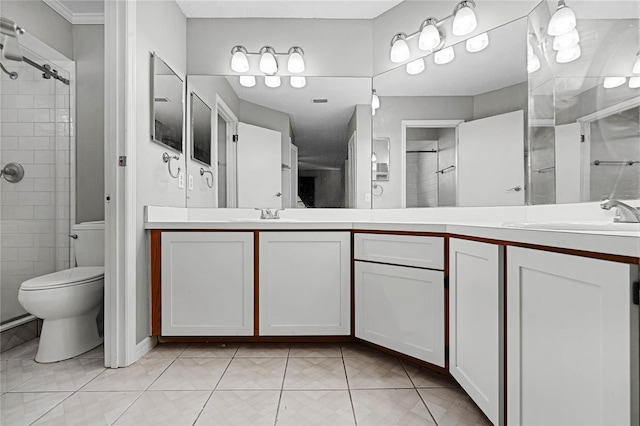 bathroom featuring double vanity, toilet, a sink, tiled shower, and tile patterned floors