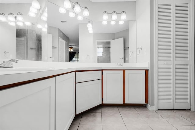 bathroom with double vanity, a stall shower, a closet, tile patterned floors, and a sink