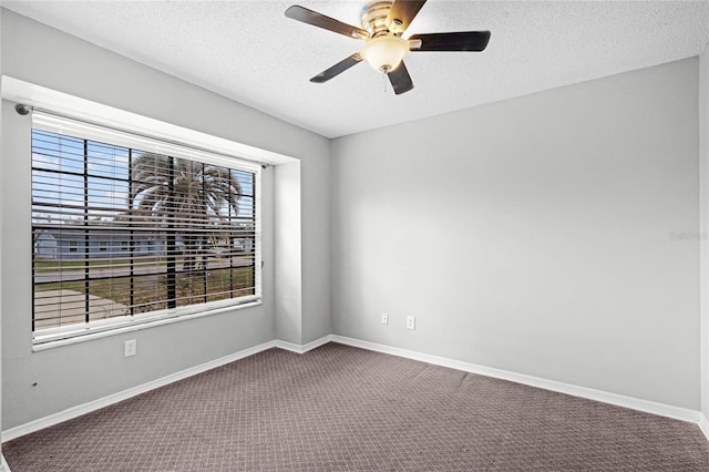 empty room with a textured ceiling, ceiling fan, carpet flooring, and baseboards