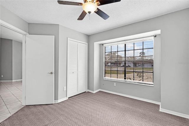 unfurnished bedroom featuring carpet floors, a closet, and a textured ceiling