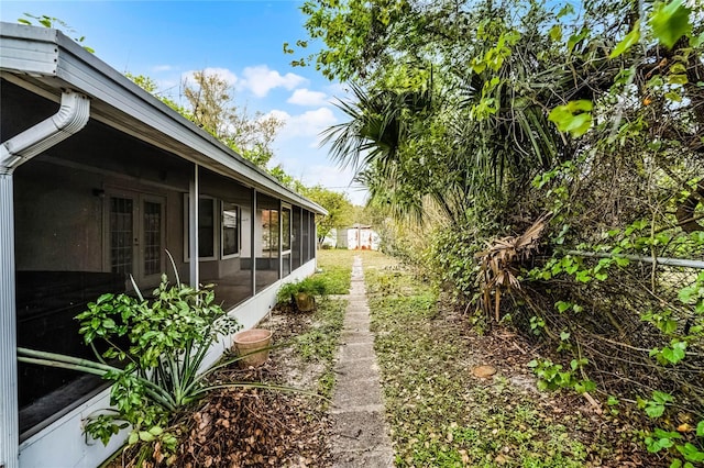 view of yard with french doors and a sunroom