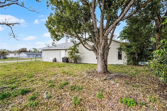 view of yard with fence and central AC unit