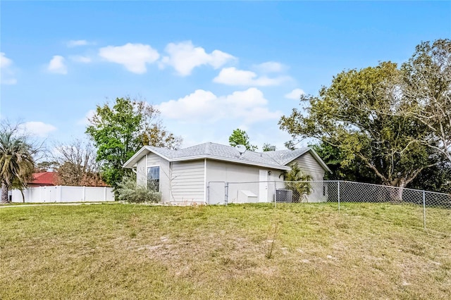 back of house featuring a yard and a fenced backyard