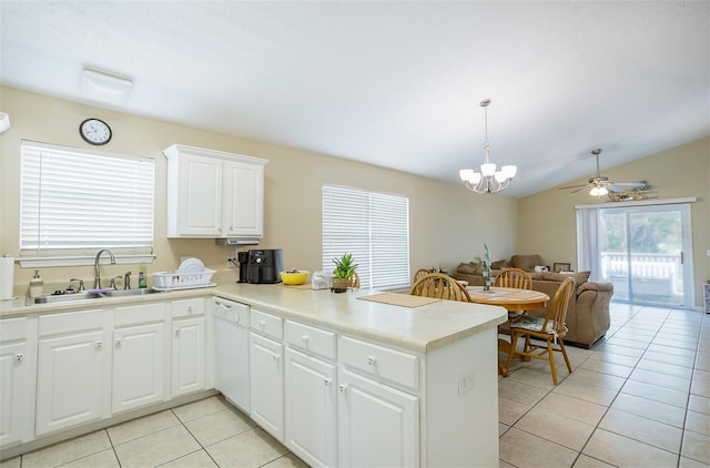 kitchen with light tile patterned floors, a peninsula, white dishwasher, and a sink