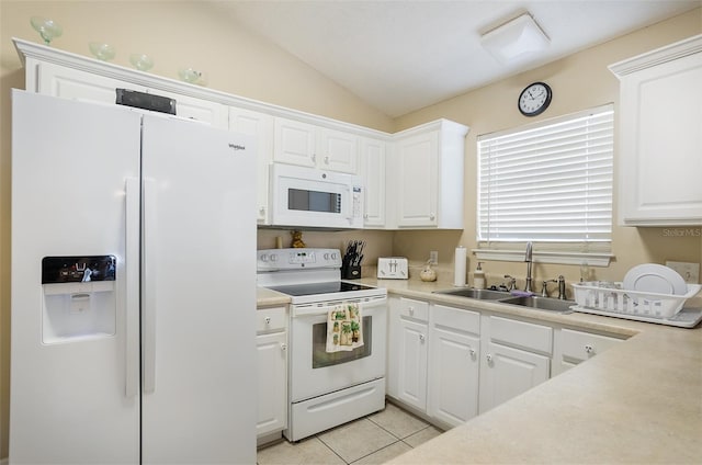 kitchen featuring white appliances, light tile patterned floors, white cabinets, vaulted ceiling, and a sink