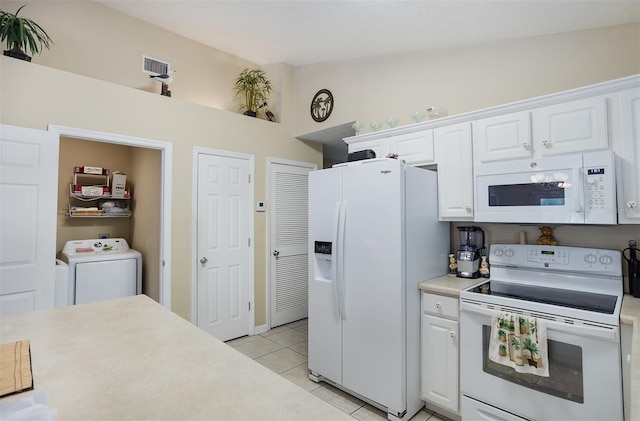 kitchen featuring white appliances, light tile patterned floors, washer / clothes dryer, light countertops, and white cabinetry