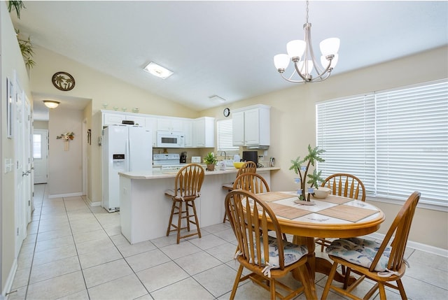 dining space with vaulted ceiling, baseboards, and light tile patterned floors