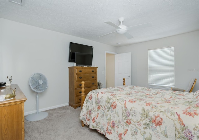 carpeted bedroom featuring a textured ceiling, ceiling fan, and baseboards