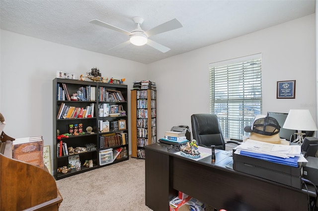 carpeted office space featuring ceiling fan and a textured ceiling