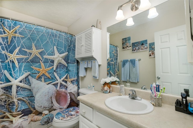 bathroom featuring toilet, a textured ceiling, and vanity