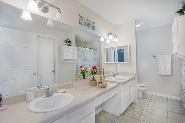 bathroom with double vanity, tile patterned flooring, toilet, and a sink