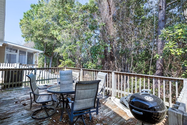 wooden deck featuring outdoor dining space and a grill