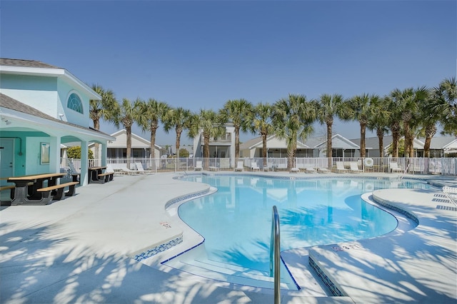 pool with a patio area and fence