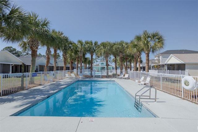 pool with a residential view, fence, and a patio