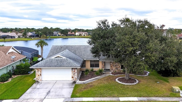 view of front of home featuring concrete driveway, stone siding, a water view, an attached garage, and a front lawn