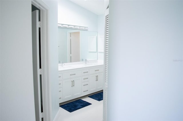 bathroom featuring a closet, a sink, and double vanity